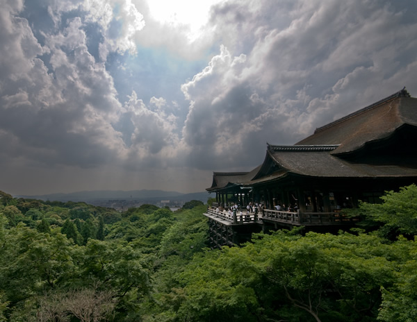 Temple asiatique en forêt, plusieurs personnes sur la terrasse